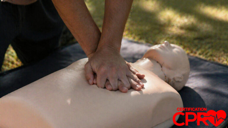 Person performing hands-only CPR on a mannequin outdoors in Arlington.